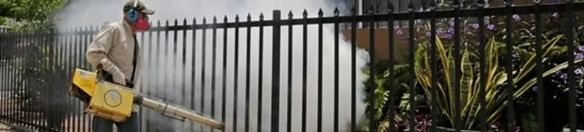 Mosquito control technician fogging a yard perimeter for mosquito reduction in Tampa, FL